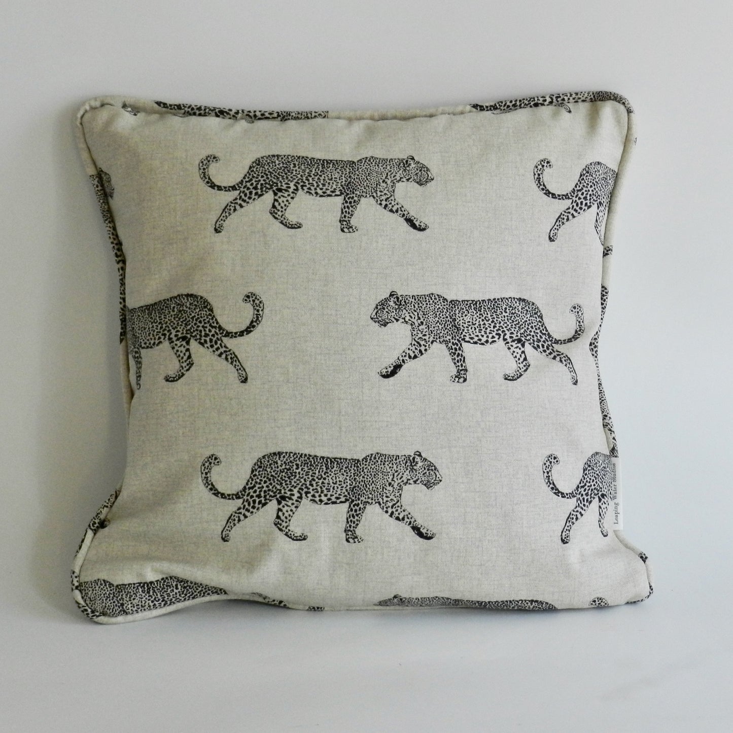 Decorative pillow with black leopard pattern on a light background