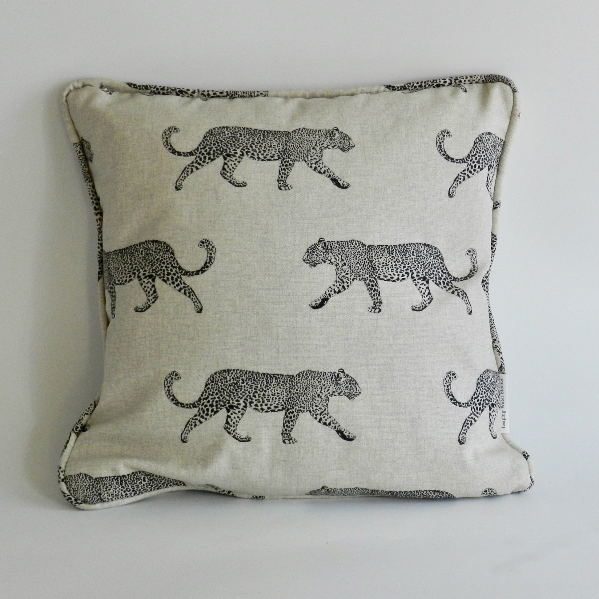 Decorative pillow with black leopard pattern on a light background