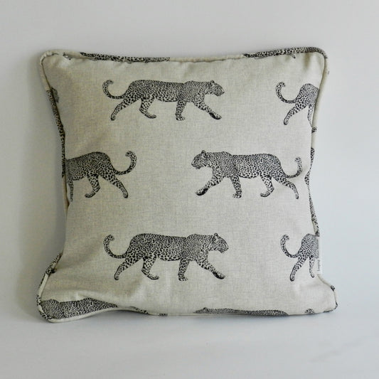 Decorative pillow with black leopard pattern on a light background